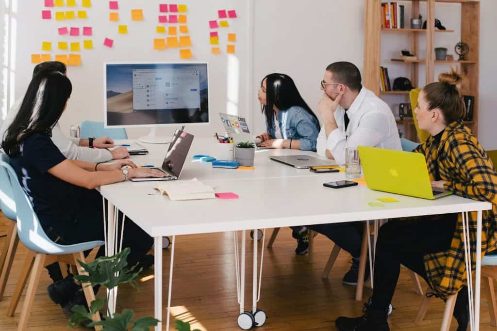 Mental Health First Aid 1 five person by table watching turned on white iMac